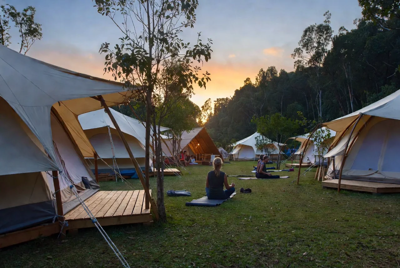 Schöner Campingplatz mit Glamping-Zelten und Menschen bei Sonnenuntergang